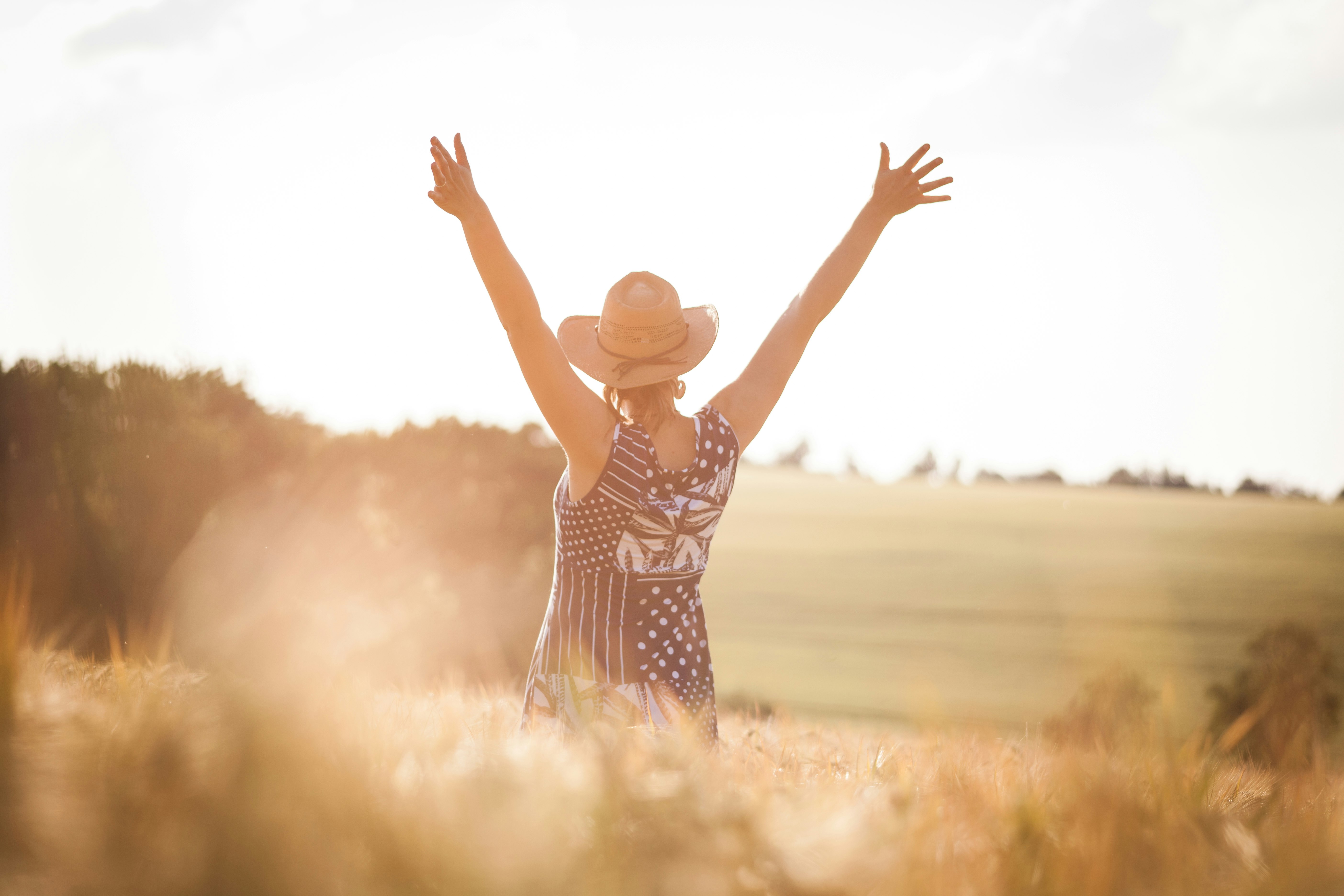 woman in black and white polka dot dress raising her hands